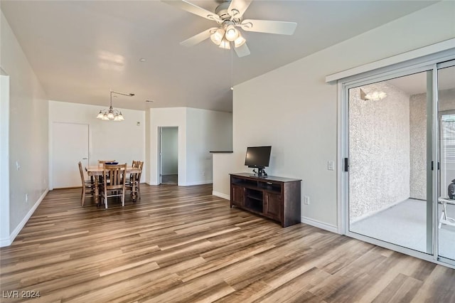 living room featuring wood-type flooring and ceiling fan with notable chandelier