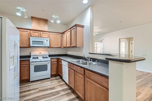 kitchen featuring kitchen peninsula, sink, white appliances, and light hardwood / wood-style flooring