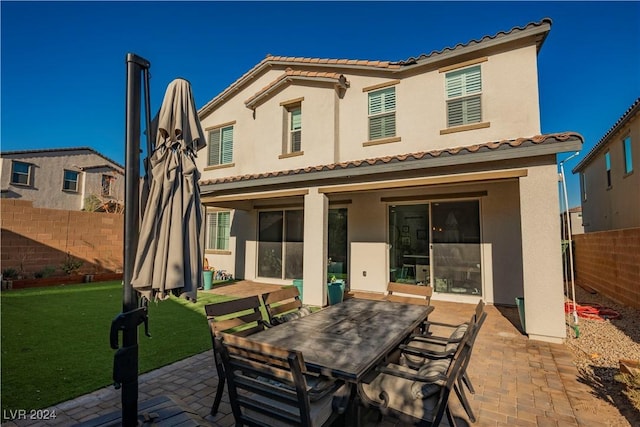 back of house with a yard and a patio