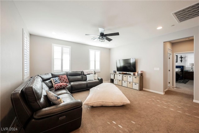 carpeted living room with ceiling fan