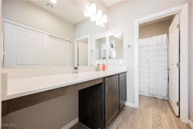 bathroom with hardwood / wood-style flooring, vanity, ceiling fan with notable chandelier, and a shower with shower curtain