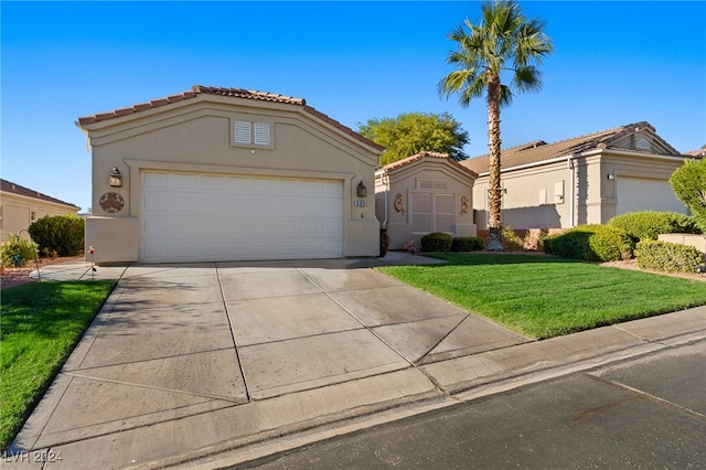 mediterranean / spanish house with a front lawn and a garage