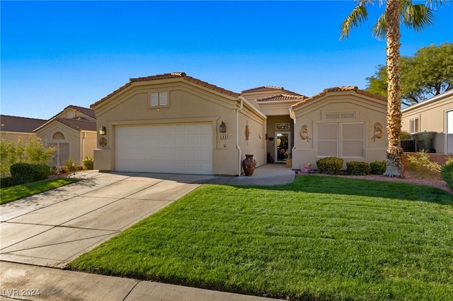 mediterranean / spanish-style house featuring a front yard and a garage