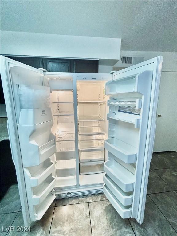 room details featuring refrigerator and a textured ceiling