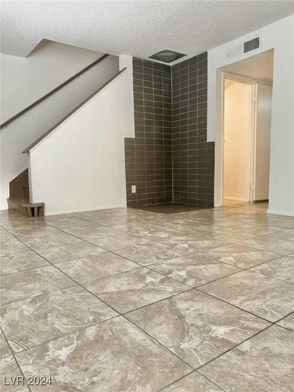 unfurnished room featuring a textured ceiling