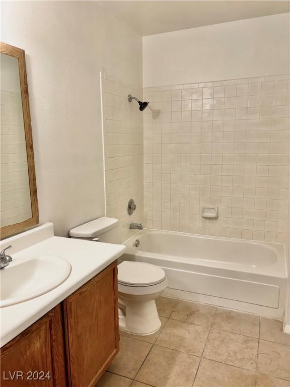 full bathroom featuring tile patterned flooring, vanity, toilet, and tiled shower / bath