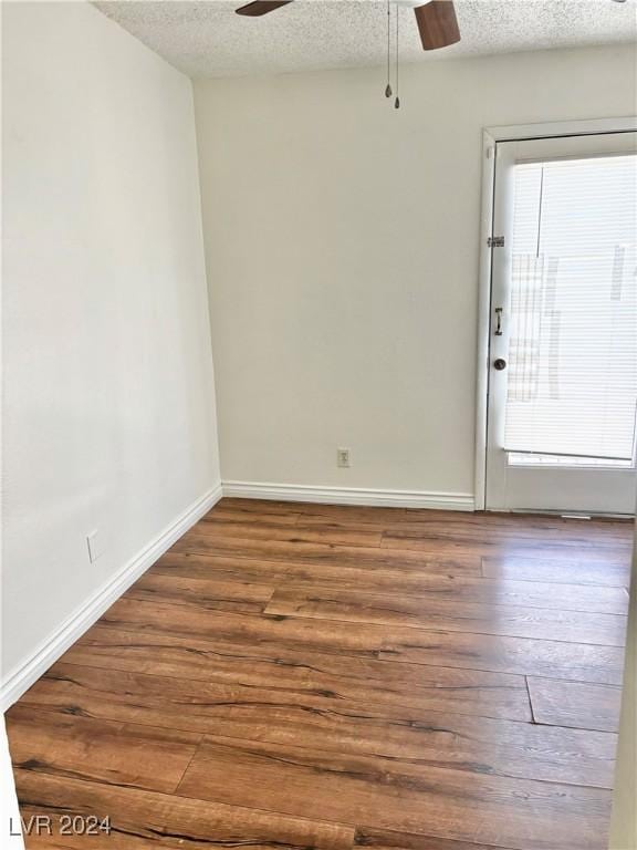 unfurnished room with a textured ceiling and hardwood / wood-style flooring