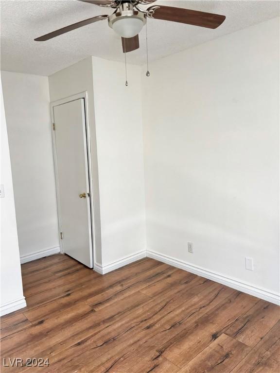 unfurnished room featuring wood-type flooring and a textured ceiling