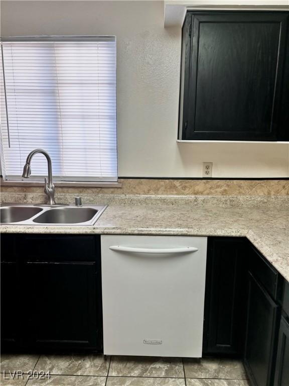 kitchen with dishwashing machine, light tile patterned floors, and sink