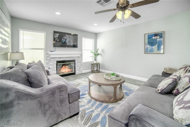 living room with a fireplace, ceiling fan, and hardwood / wood-style floors