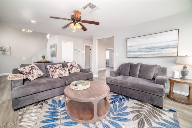 living room with ceiling fan and light hardwood / wood-style flooring