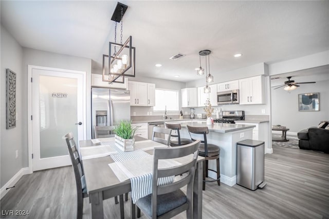 dining room featuring light hardwood / wood-style floors, ceiling fan, and sink