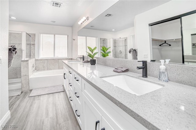 bathroom featuring hardwood / wood-style floors, vanity, and independent shower and bath