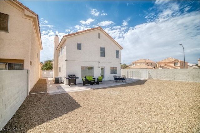 rear view of house with cooling unit and a patio area