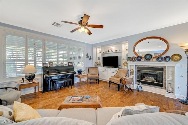 living room featuring wood-type flooring, ceiling fan, and crown molding