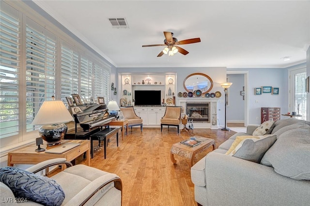 living room with crown molding, plenty of natural light, ceiling fan, and light hardwood / wood-style floors