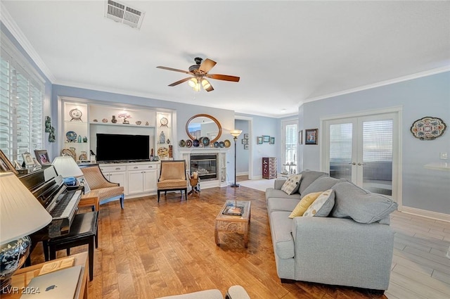 living room with crown molding, french doors, ceiling fan, and light hardwood / wood-style floors