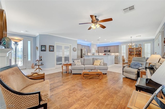 living room with light hardwood / wood-style flooring, plenty of natural light, and crown molding