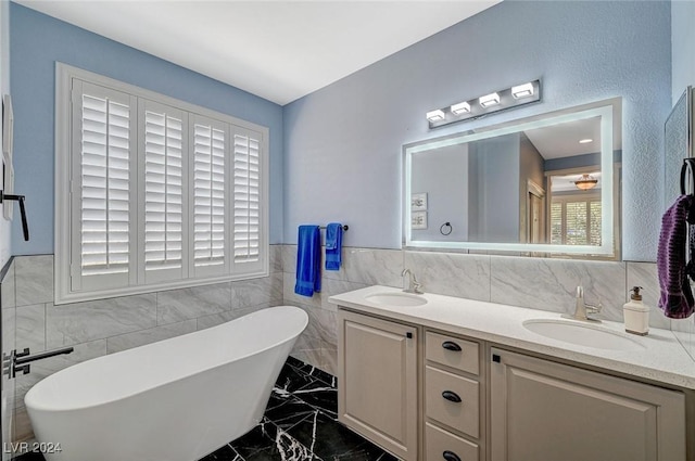 bathroom with vanity, a bath, and tile walls