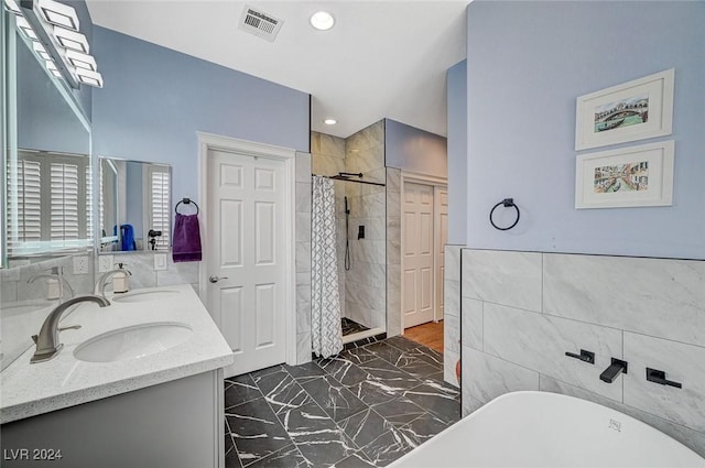 bathroom with vanity, separate shower and tub, and tile walls