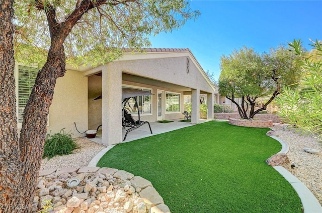 rear view of property with a patio and a lawn