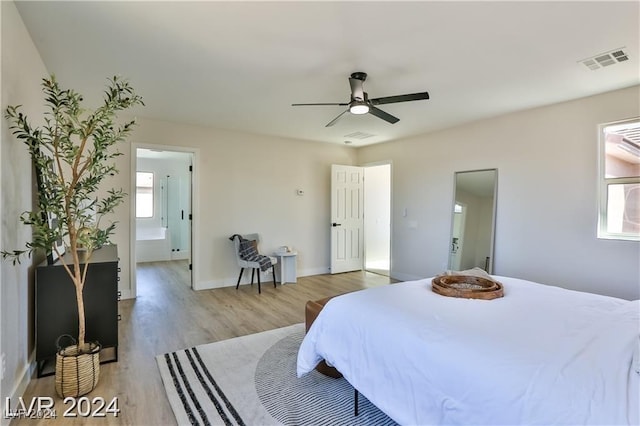 bedroom with light hardwood / wood-style flooring, ensuite bath, and ceiling fan