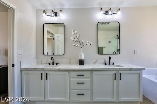 bathroom featuring vanity and tiled tub