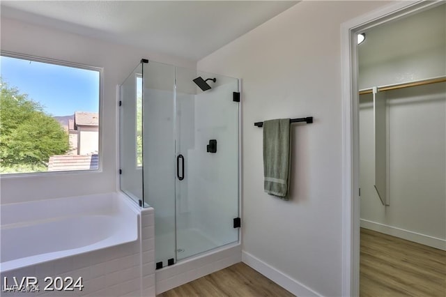 bathroom featuring hardwood / wood-style flooring and shower with separate bathtub