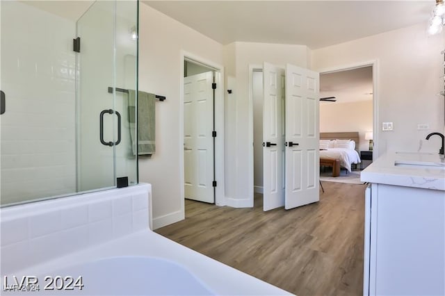 bathroom with hardwood / wood-style flooring, vanity, and separate shower and tub