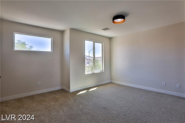 unfurnished room with plenty of natural light and carpet