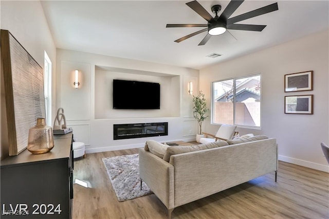 living room with ceiling fan and light hardwood / wood-style flooring