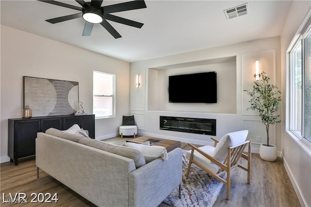 living room with ceiling fan and dark hardwood / wood-style flooring