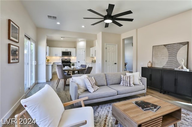 living room featuring hardwood / wood-style flooring and ceiling fan