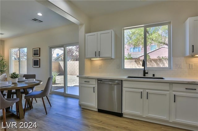 kitchen featuring white cabinetry, stainless steel dishwasher, and plenty of natural light