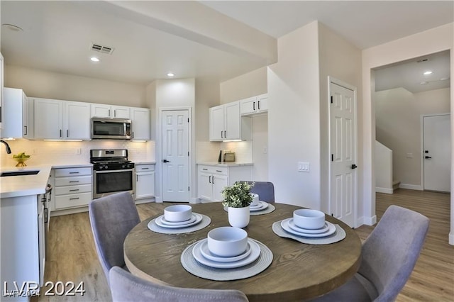 dining space featuring sink and light hardwood / wood-style flooring