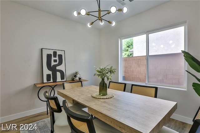 dining area with hardwood / wood-style floors and a notable chandelier