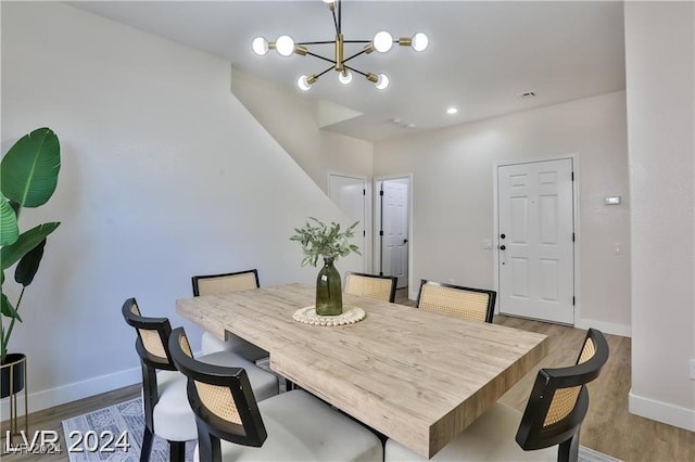 dining area featuring hardwood / wood-style floors and an inviting chandelier