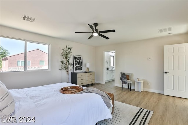 bedroom with ceiling fan, ensuite bathroom, and light hardwood / wood-style floors