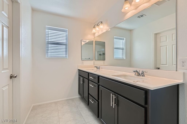 bathroom featuring tile patterned flooring, vanity, and a healthy amount of sunlight