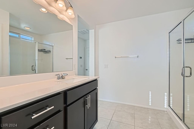 bathroom with tile patterned flooring, vanity, and a shower with door