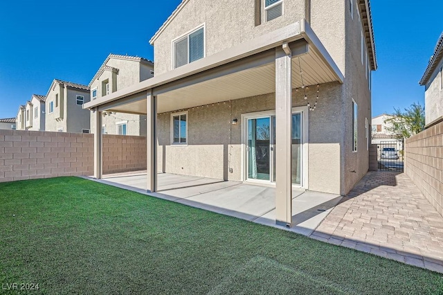 back of house with a yard and a patio