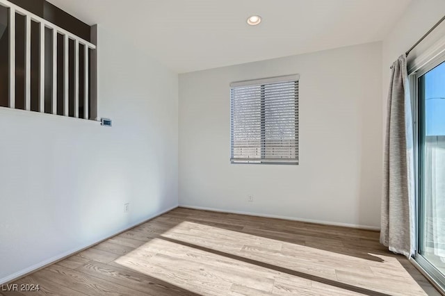 unfurnished room featuring plenty of natural light and wood-type flooring