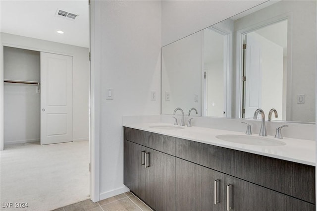 bathroom with tile patterned floors, visible vents, a sink, and double vanity