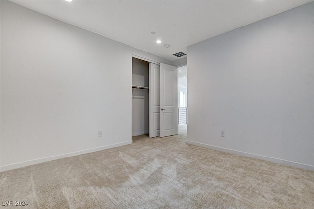 unfurnished bedroom with recessed lighting, carpet floors, visible vents, baseboards, and a closet