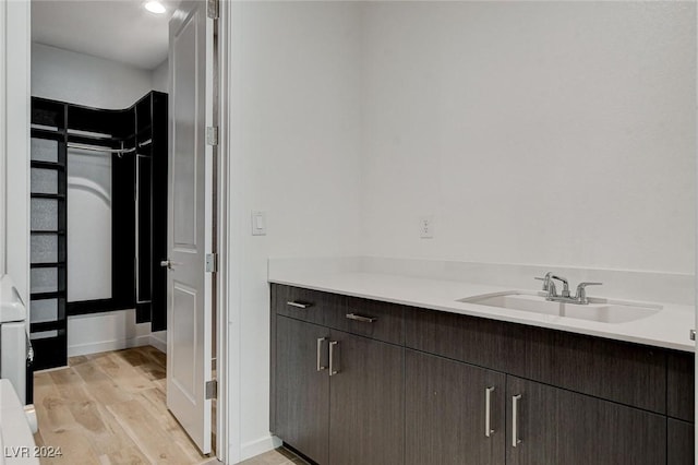 bathroom with wood finished floors, vanity, and baseboards