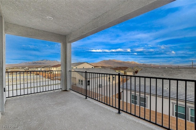 balcony featuring a residential view and a mountain view