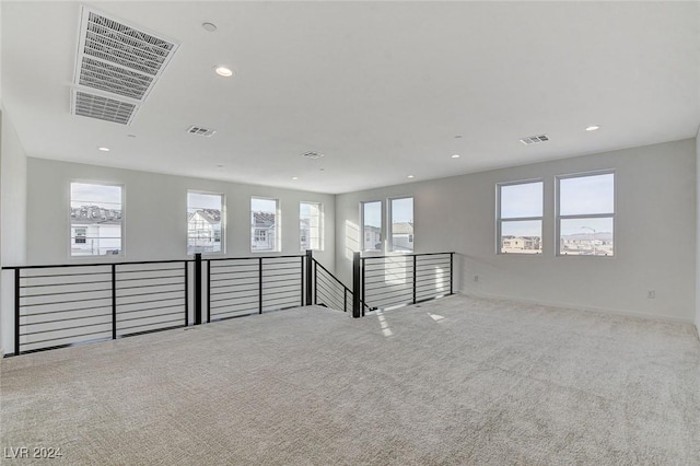 unfurnished room featuring carpet floors, a wealth of natural light, visible vents, and recessed lighting