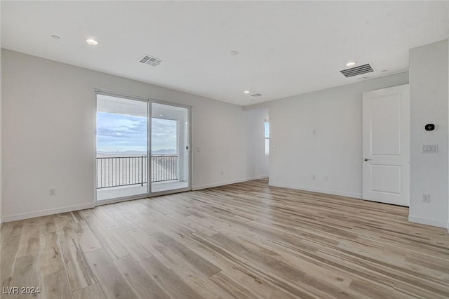 spare room with light wood-type flooring, baseboards, visible vents, and recessed lighting