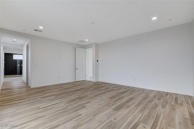 spare room featuring light wood-style flooring, visible vents, baseboards, and recessed lighting