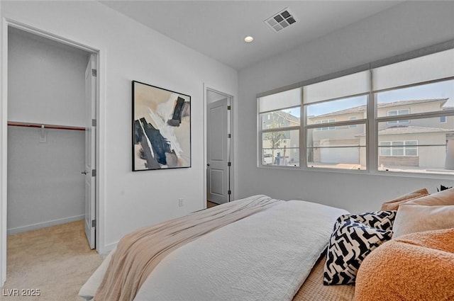 bedroom featuring recessed lighting, visible vents, a spacious closet, light carpet, and baseboards